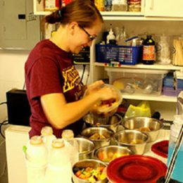 Female primate husbandry intern preparing lemur diets