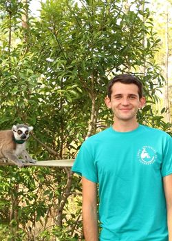 LCF Keeper Michael Barnas looks at camera with ring-tailed lemur in background